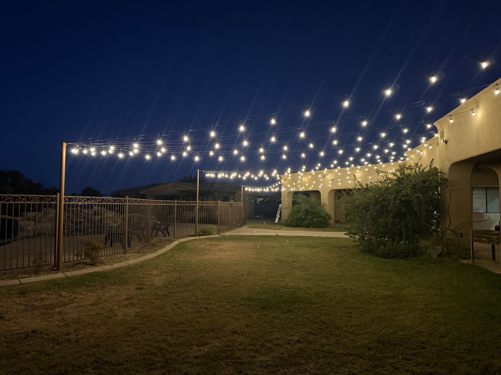 Bistro string lighting over backyard entertaining area